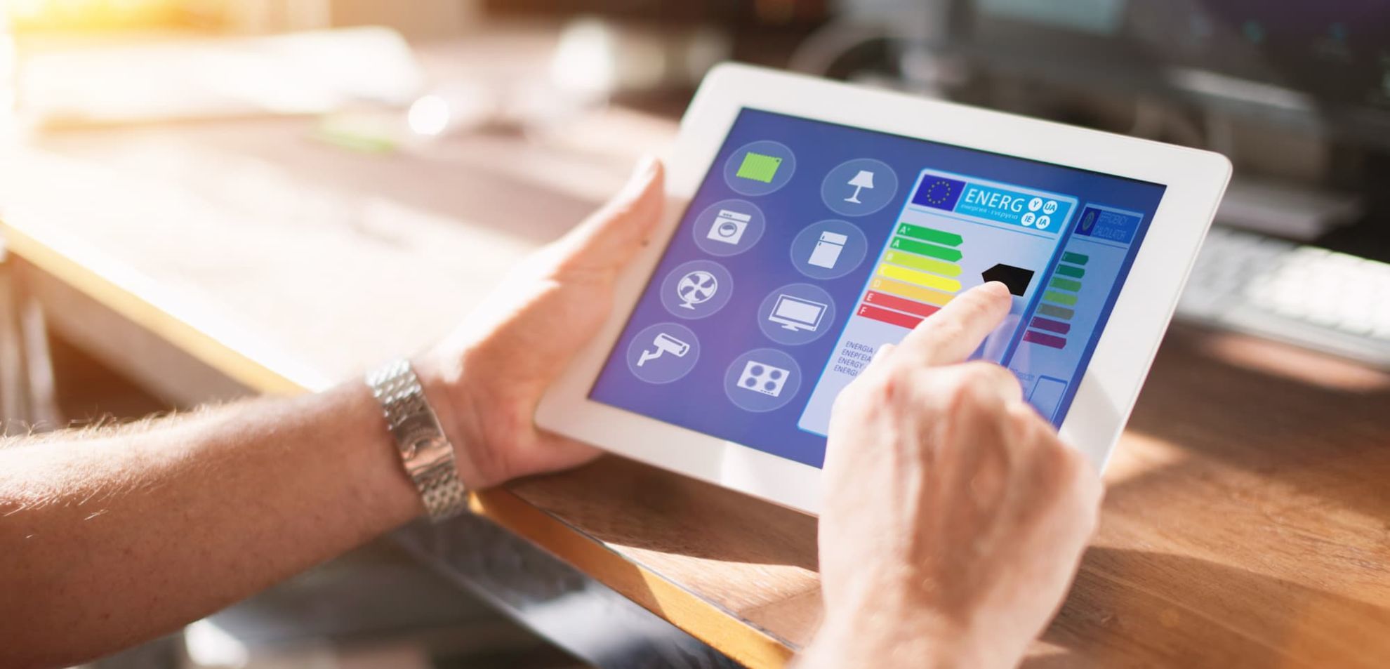 Zwei Hände halten ein Tablet. Auf dem Display können Smart-Home Einstellungen vorgenommen werden.
